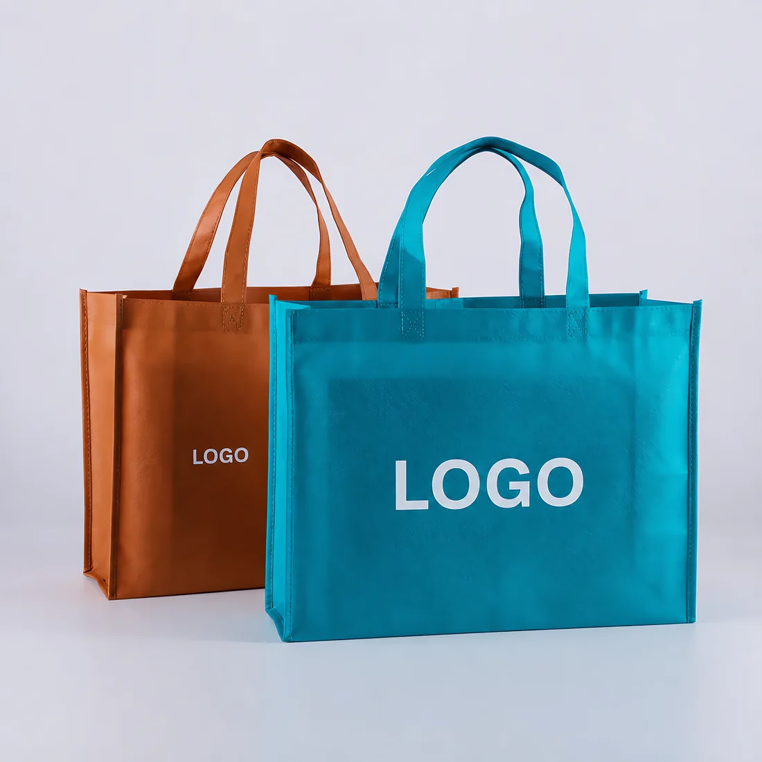Two colored non-woven promotional bags showing generic LOGO print positions